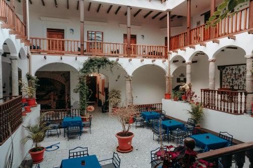 基多Hotel Casa Alquimia的建筑中带蓝色桌椅的庭院