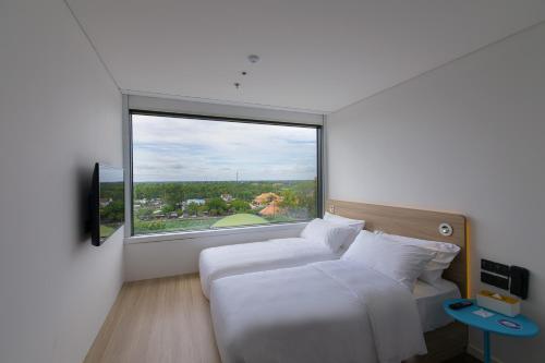 Vị ThanhSOJO Hotel Hau Giang的一间卧室设有两张床和大窗户