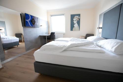 施韦夏特Das Reinisch Just Rooms的一间卧室配有两张白色的床和一张书桌