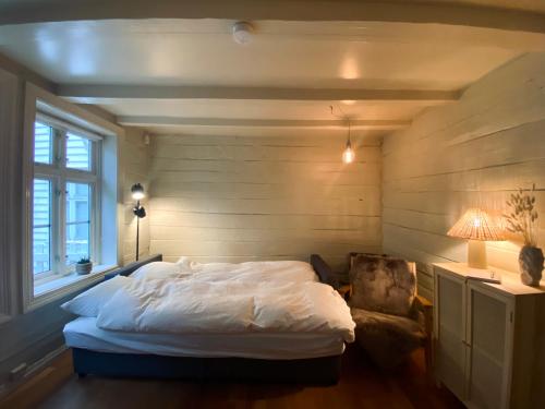 卑尔根Charming Bergen house, rare historic house from 1779, Whole house的一间卧室配有一张床、一把椅子和一盏灯