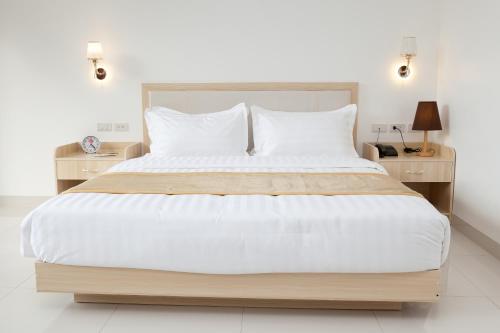 爱妮岛One El Nido Suite的卧室配有一张带白色床单和枕头的大床。