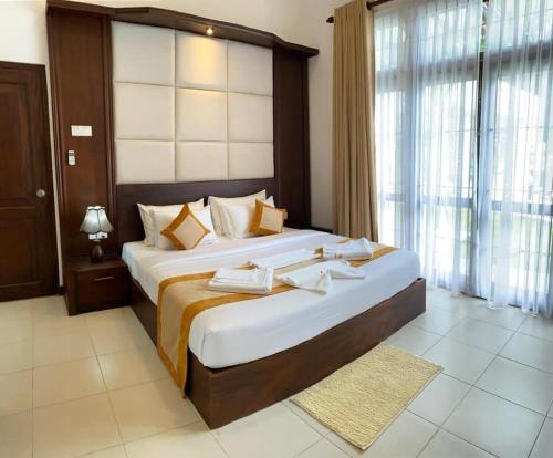 锡吉里亚Serenity Villa Dambulla的一间卧室设有两张床和大窗户