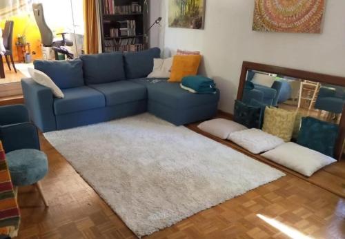 卡西斯Chambre hôte Residence sous les pins的客厅配有蓝色的沙发和地毯。