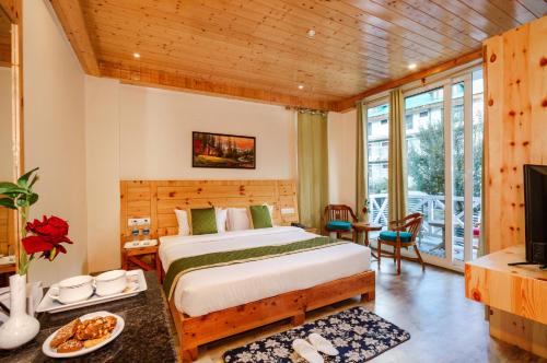 马拉里Tripli Hotels Stone House Cottage的一间卧室配有一张床,并在一间客房内配有电视。