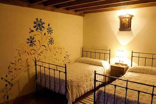 TormellasLa Torre del Molino es una casa rural ubicada sobre un antiguo molino的一间卧室设有两张床和一堵墙