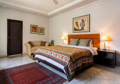 加尔各答Neelam Bed & Breakfast的一间卧室配有一张大床和一张沙发