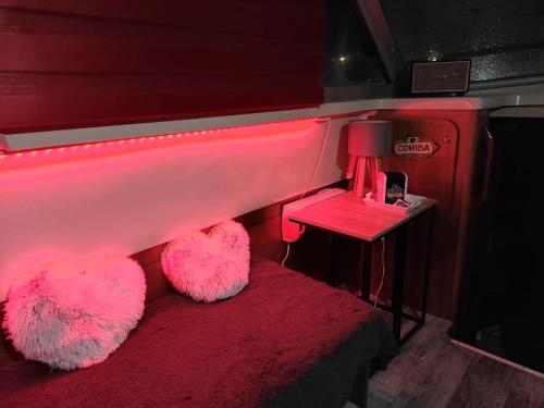 乌伊斯特勒昂Nuit insolite sur l'eau au port de Ouistreham的客房设有一张粉红色的床和桌椅
