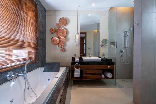 努沙杜瓦Tanadewa Villas Nusa Dua Bali by Cross Collection的带浴缸、水槽和镜子的浴室