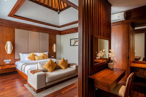 努沙杜瓦Tanadewa Villas Nusa Dua Bali by Cross Collection的一间卧室配有一张沙发和一张桌子。