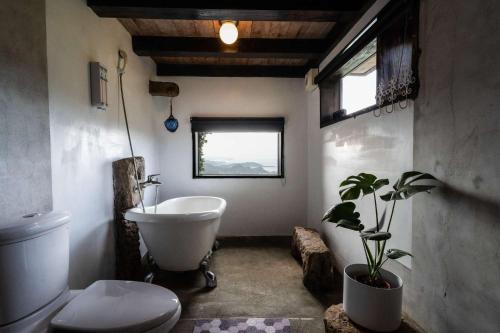 九份阳光味宿的浴室配有白色浴缸、卫生间和植物