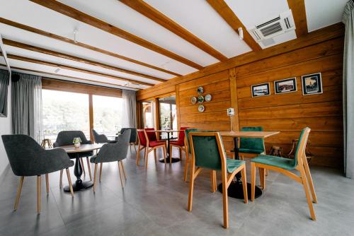 斯沃尔纳加西耶Chaber Apartamenty的用餐室设有木墙、椅子和桌子