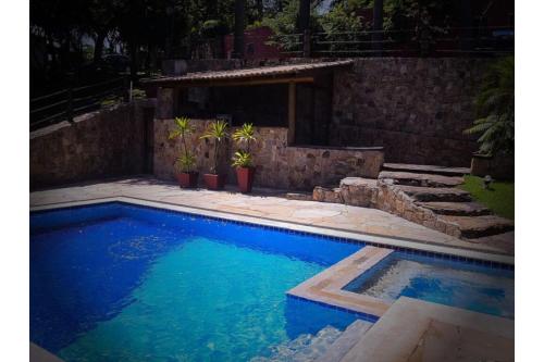 圣罗克OYO Pousada e Hotel Putini的庭院里的一个蓝色海水游泳池