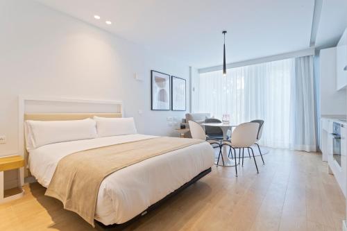 马德里Uma Suites O'Donnell的卧室配有一张床和一张桌子及椅子