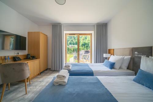 什恰夫尼察Willa Pod Kolejką的酒店客房配有两张床和一张书桌
