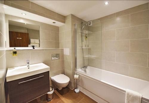 圣彼得港公爵酒店的浴室配有盥洗盆、卫生间和浴缸。
