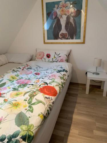 埃姆登Ferienwohnung Lüttje Hörn的一张床上的一张,有一张牛的照片