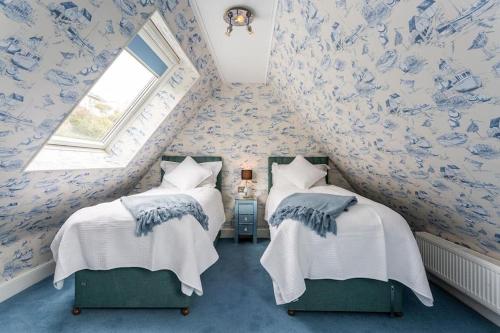 桑盖特The luxury Beach property - Oceanbreeze的配有两张蓝色和白色壁纸的床铺