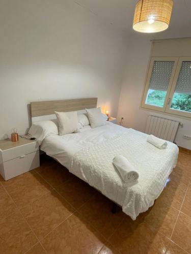 赫罗纳Casa Veuràs Girona - Montilivi的一间卧室配有一张大床和两条毛巾