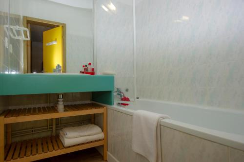 OzRésidence Capfun Couleurs Soleil, Oz en Oisans的一间带水槽、浴缸和镜子的浴室