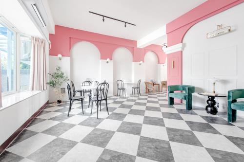 台东H& 台東敲敲門無人別館 l 近火車站 l 全自助入住的一间设有 ⁇ 形地板和粉红色墙壁的客房