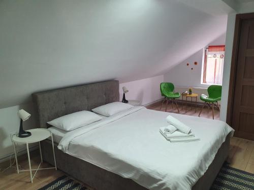 古拉哈莫卢洛伊Casa Saga的一间卧室配有一张床和两张绿色椅子