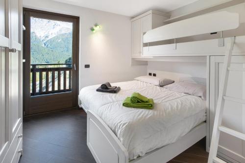 瓦尔迪索托Appartamento Silvia的一间卧室配有一张带两张绿毛巾的床