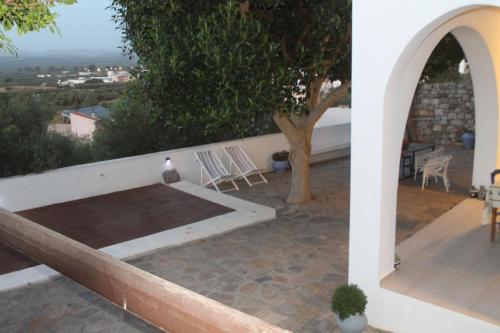 PírgosA Crystal Clear House in Pyrgos, Heraklion Crete的一个带桌椅和树的庭院