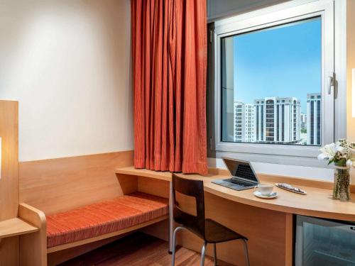 阿达纳阿达纳宜必思酒店的客房设有一张带笔记本电脑和窗户的书桌。