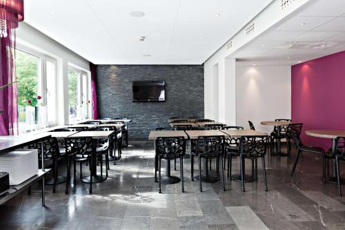 哥德堡Hotel Allén - Sure Hotel by Best Western Allen的一间带桌椅的餐厅以及带电视的墙壁