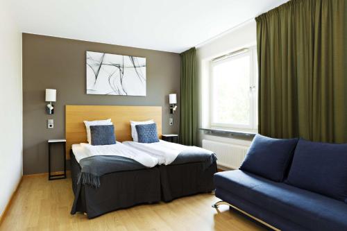哥德堡Hotel Allén - Sure Hotel by Best Western Allen的一间卧室配有一张床和一张沙发