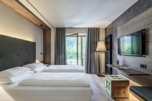 蒙圭尔福克里斯托夫酒店的一间大卧室,配有两张床和电视