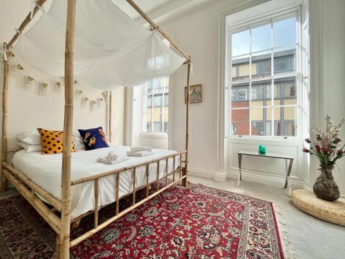 诺丁汉Unique & Luxurious 2 Bedroom City Centre Apartment的一间卧室配有一张红色地毯的天蓬床