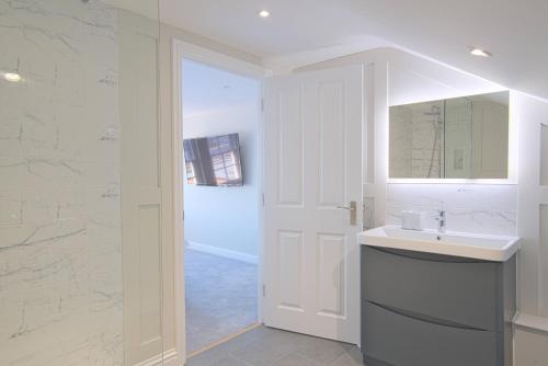 邓斯特布尔Harper Luxe Serviced Apartments Dunstable的白色的浴室设有水槽和镜子