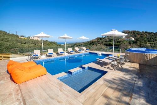 埃皮斯科皮Etesians Villa, an essence of timeless beauty, By ThinkVilla的一个带橙色沙发、椅子和遮阳伞的游泳池