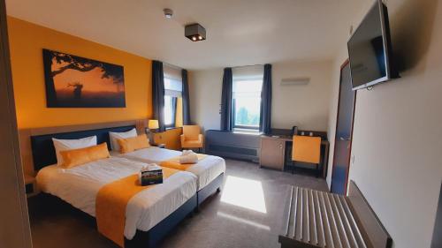 杜柏奥兹恩阿登纳酒店的一间卧室配有一张床和一台平面电视