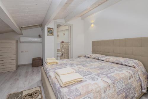 奥尔比亚Villetta a Mare的一间卧室配有一张大床和毛巾