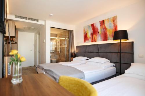 奥帕提亚Hotel Paris的配有两张床铺的酒店客房 - 带桌椅