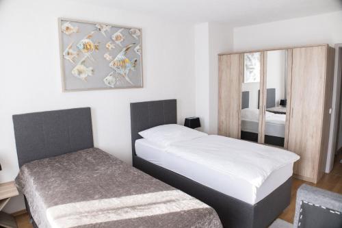 杜伊斯堡T&K Apartments near Messe Fair Trade Düsseldorf und Airport 1B的一间小卧室,配有两张床和镜子