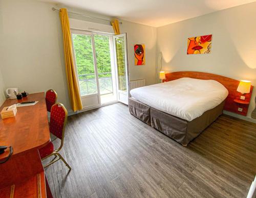 Vienne-le-Château图里皮埃尔餐厅酒店的一间卧室配有一张床、一张书桌和一个窗户。