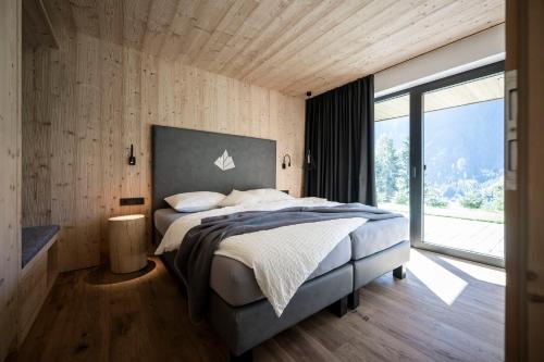 瓦尔迪维泽Stelza Nature Chalet的一间卧室设有一张大床和一个大窗户