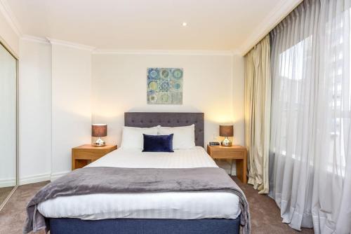 悉尼Huge Exec Apartment -Fantastic CBD Location B21001的一间卧室设有一张大床和两个床头柜