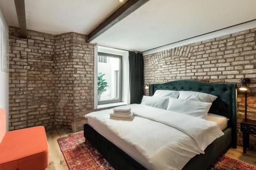 柏林Ancient 33sqm 2room maisonette apt Near center的一间卧室设有一张大床和砖墙