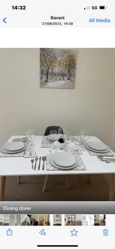 切尔滕纳姆Luxury Town Centre Property with parking的一张带盘子和酒杯的白色桌子