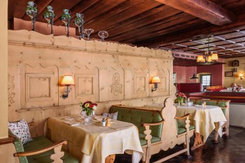 克洛斯特斯Hotel Chesa Grischuna的一间在房间带两张桌子和椅子的餐厅