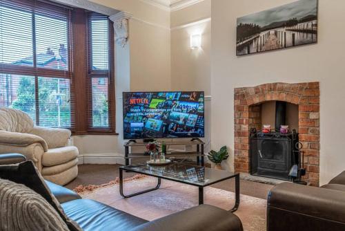 乔利Contractors accommodation in Chorley by Lancashire Holiday Lets的客厅设有壁炉和电视。