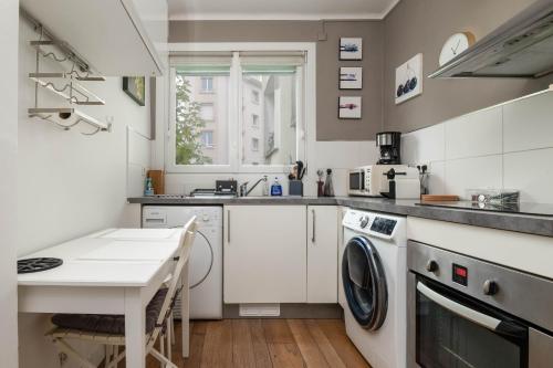 布雷斯特Brest : charmant appartement hypercentre的厨房配有洗衣机和桌子