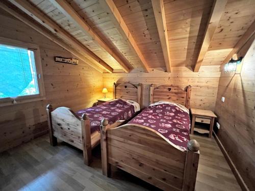 拉克吕萨Aulp de Suz 2 - Chalet avec vue的木墙客房的两张床