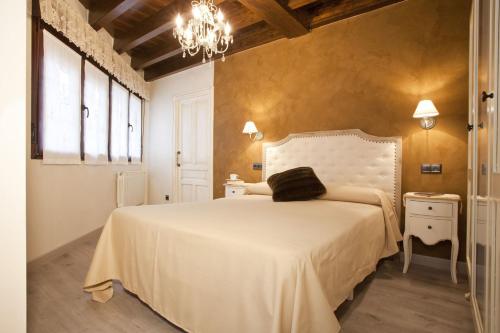 波拉·德莱纳Apartamentos El Aramo Asturias的卧室配有白色的床和吊灯。