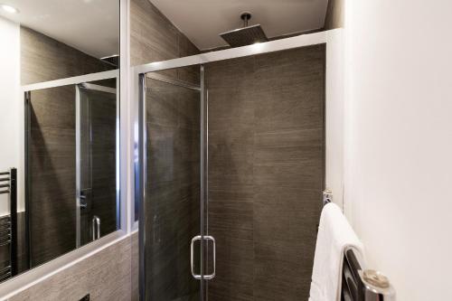 伦敦Spacious 4 bedrooms flat in New Oxford Street的浴室里设有玻璃门淋浴