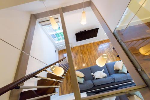 伦敦Spacious 4 bedrooms flat in New Oxford Street的客厅设有蓝色的沙发和楼梯。